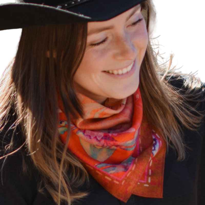 Woman wearing a colorful scarf and black hat, smiling outdoors.