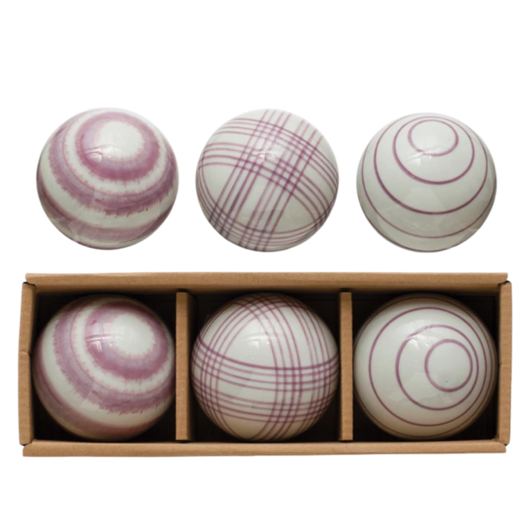 Set of six striped balls in a wooden box on a white background