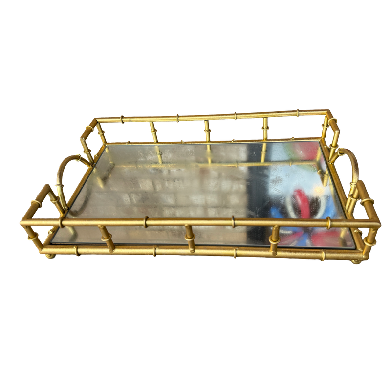 A rectangular serving tray with a gold-toned metal frame designed to look like bamboo stalks, featuring a clear glass tray insert and loop handles on the sides, shown against a plain white background.