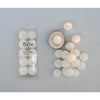 Flare brand teacandle packaging with lit candles on a gray background