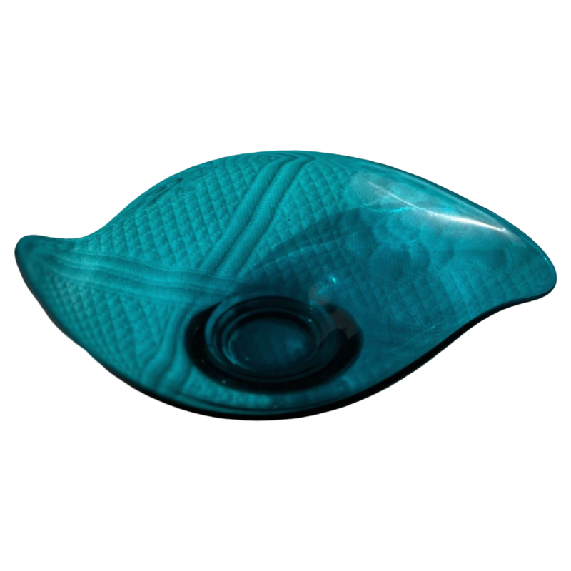 Teal glass bowl with textured surface on a white background