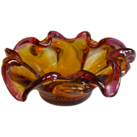 Glass bowl with wavy design in amber and red on a white background