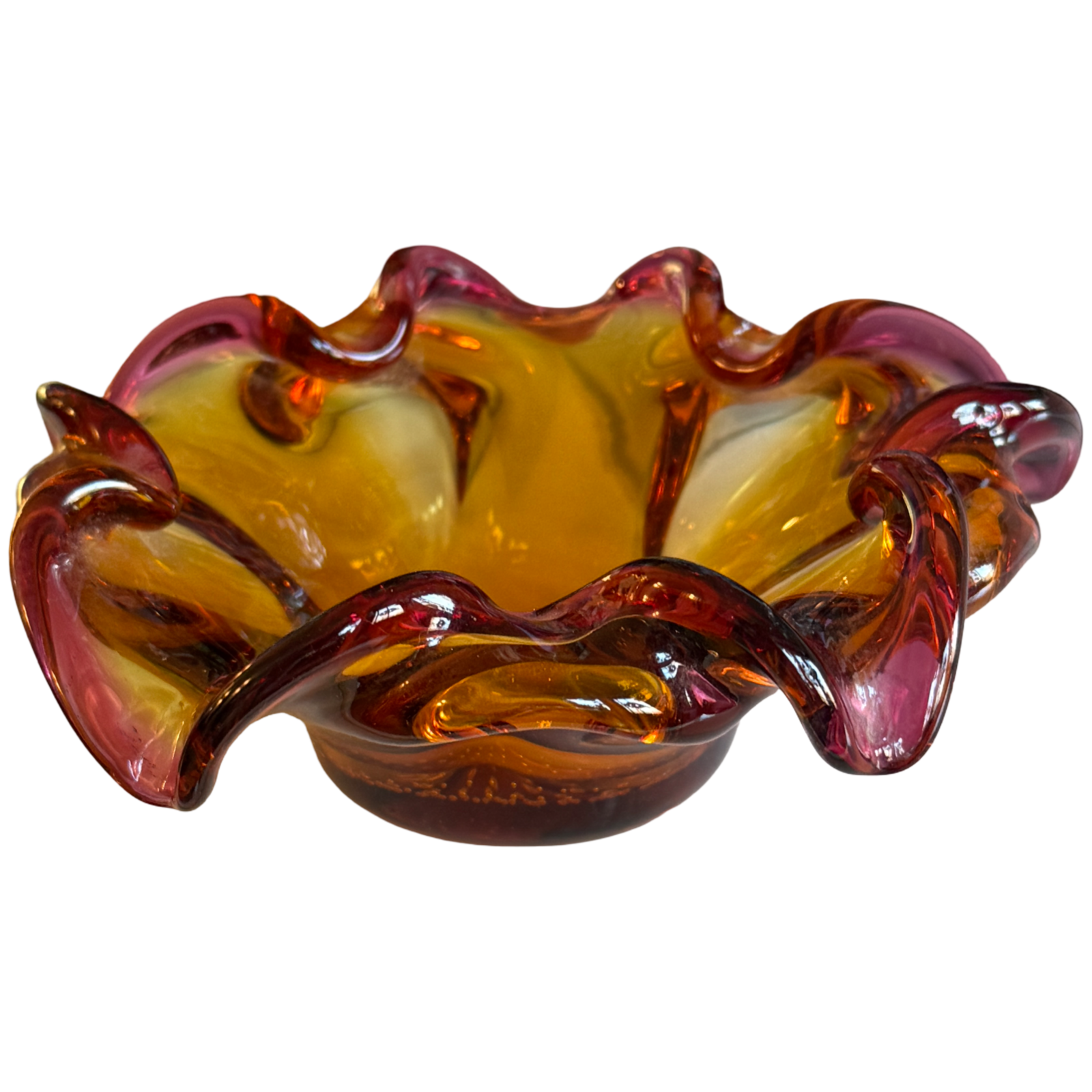 Glass bowl with wavy design in amber and red on a white background