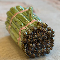 Ceramic bundle of sticks with textured ends on a patterned fabric background