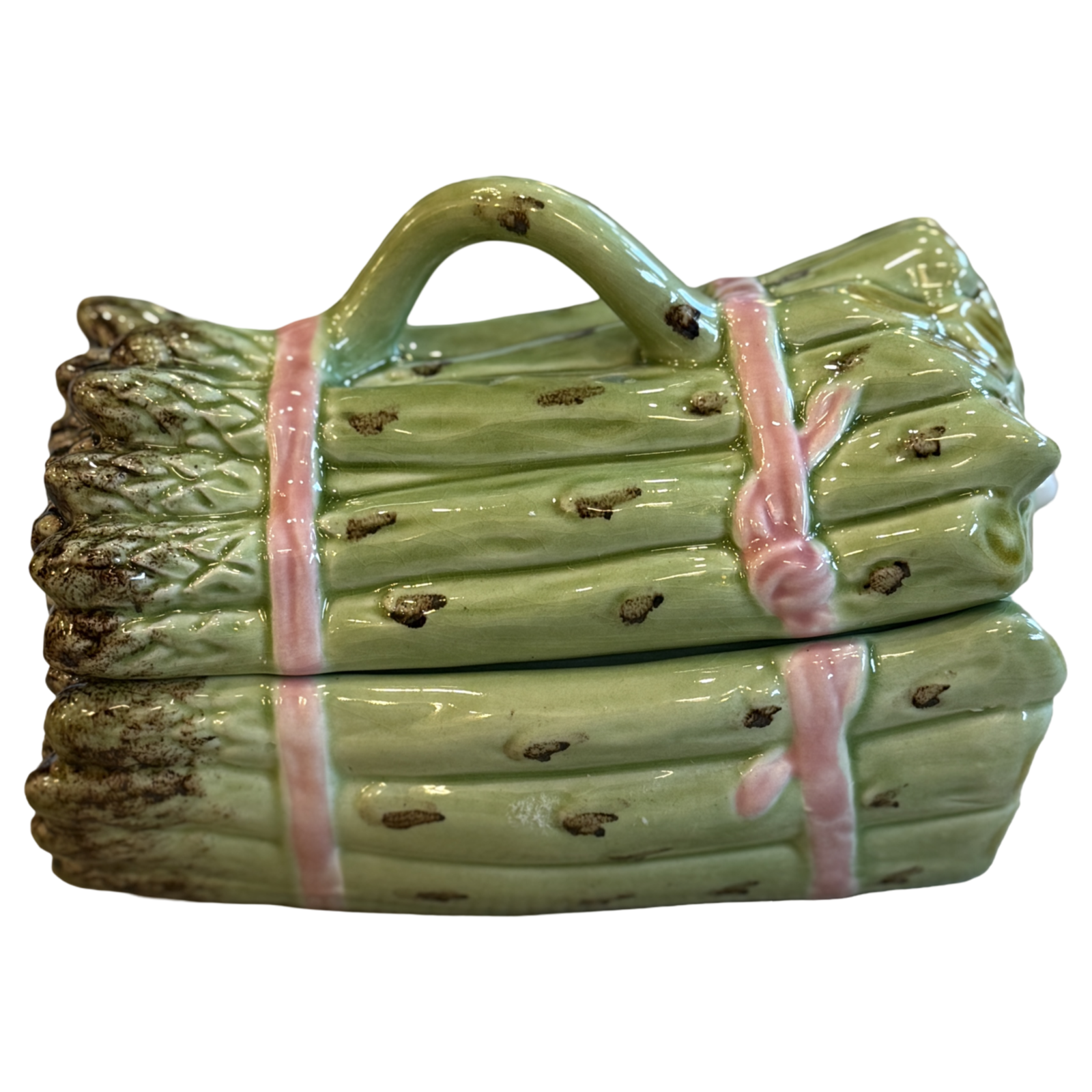 Ceramic log-shaped object with a handle on a white background