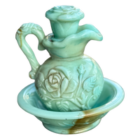 Decorative ceramic oil lamp with floral designs on a white background
