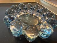 Clear glass ashtray with spherical designs on a reflective surface