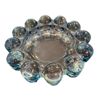 Clear glass candle holder with spherical designs on a white background