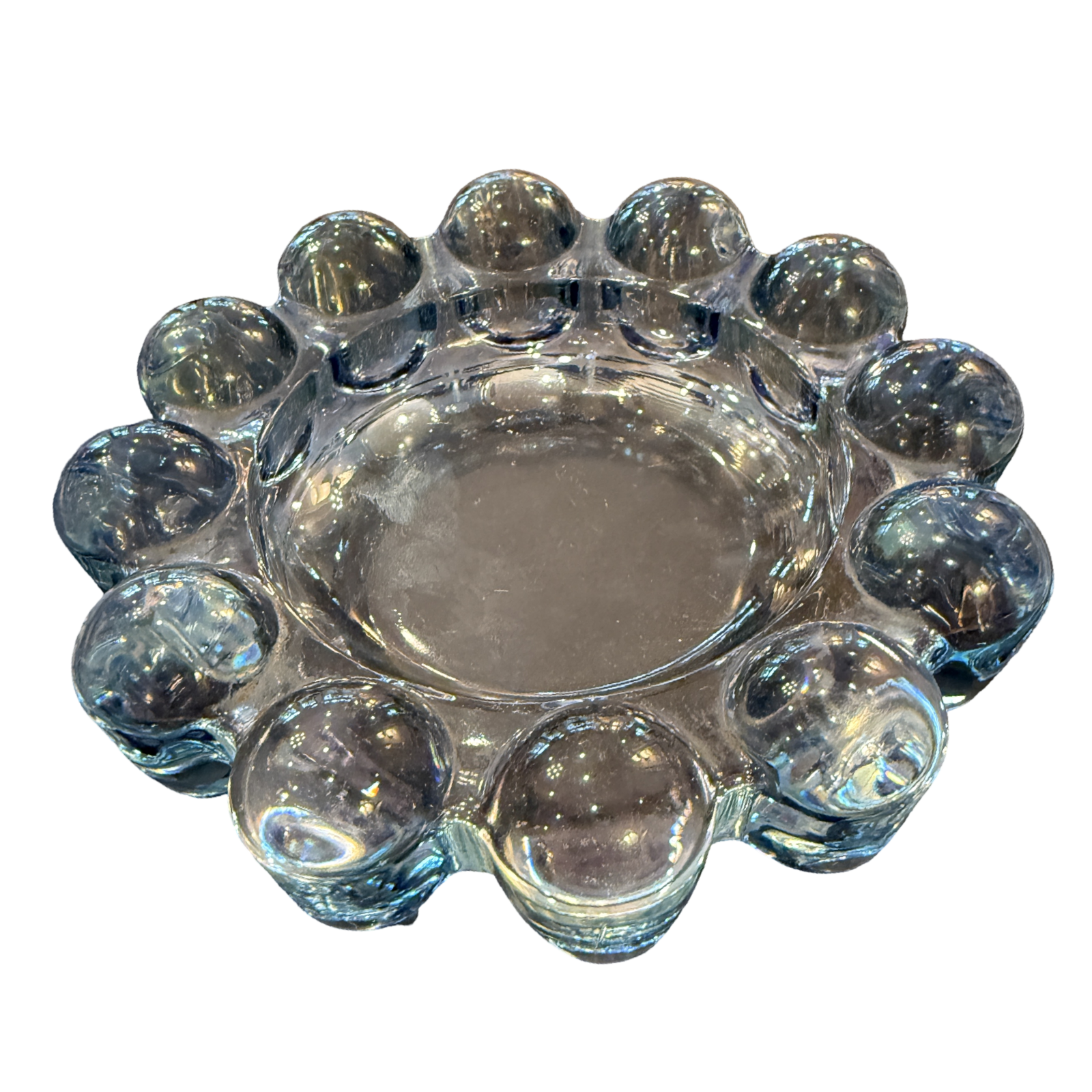 Clear glass candle holder with spherical designs on a white background