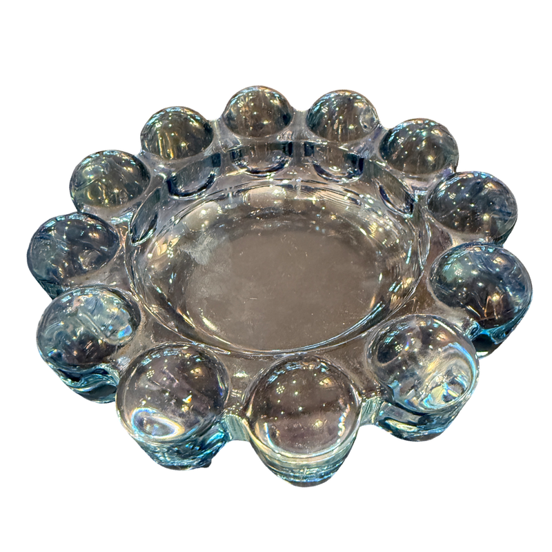 Clear glass candle holder with spherical designs on a white background