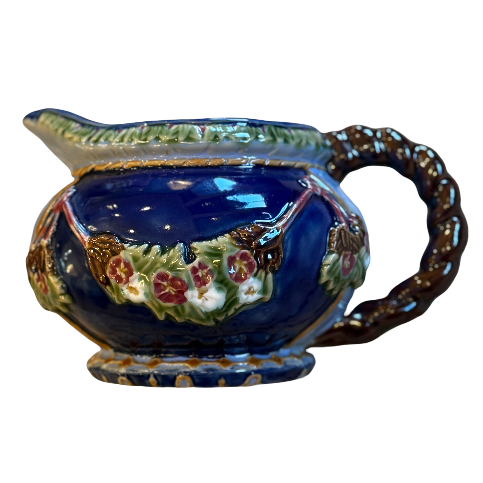 Decorative ceramic gravy boat with floral patterns on a white background