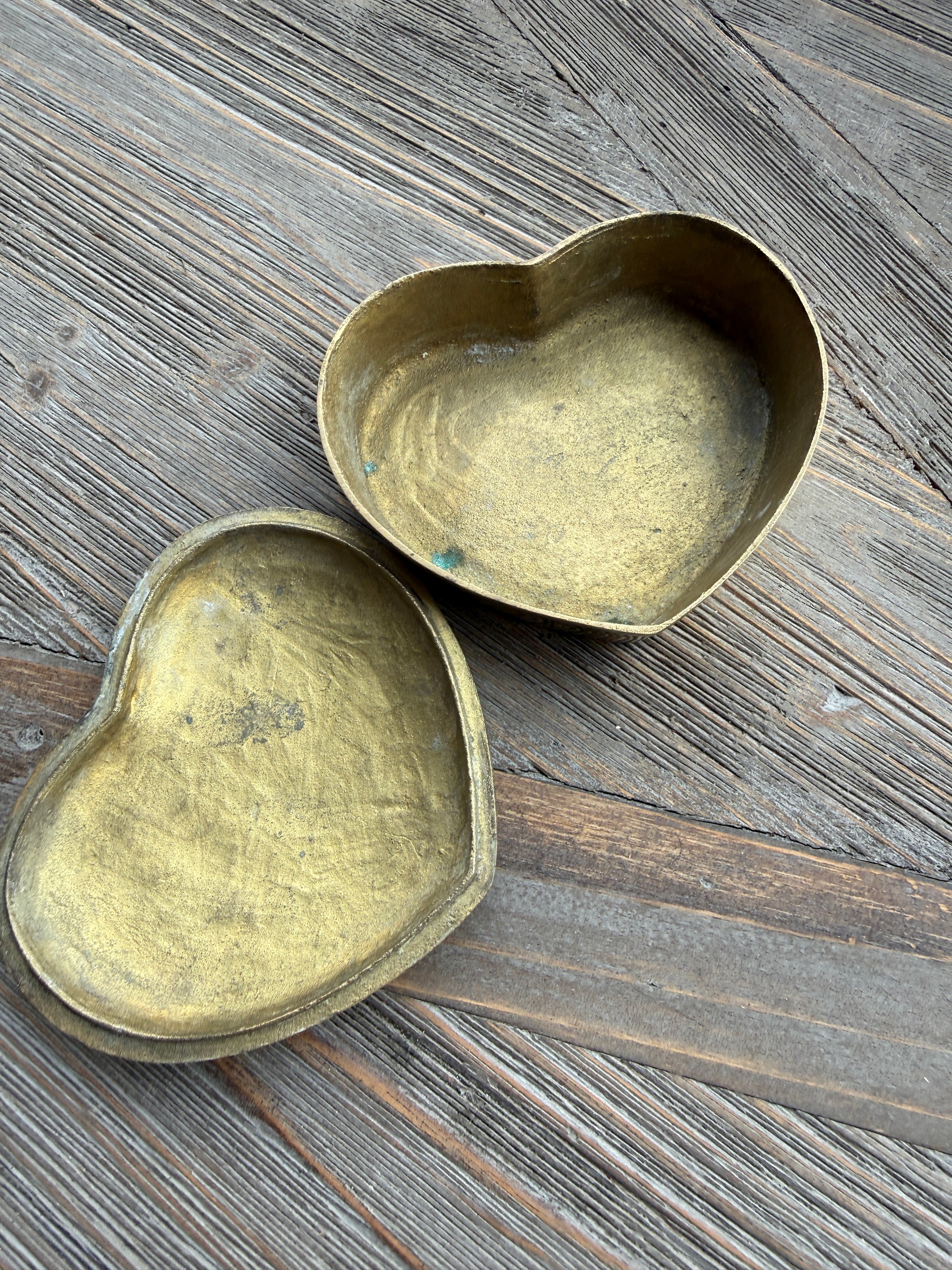 Two brass bowls on a wooden surface