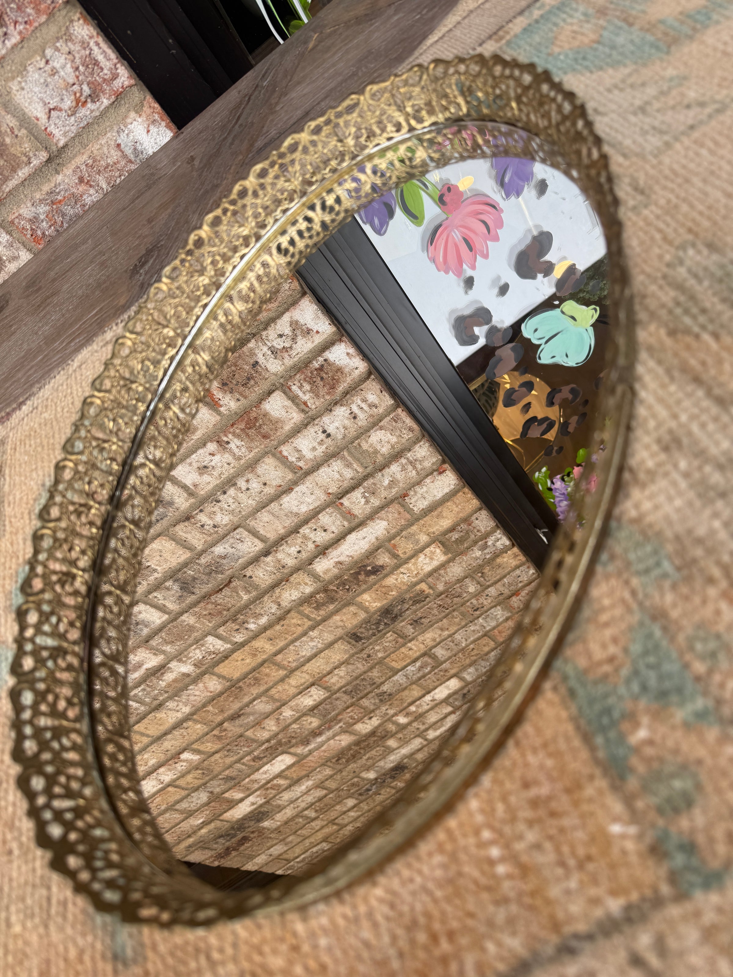 Decorative round mirror with floral design on a textured surface