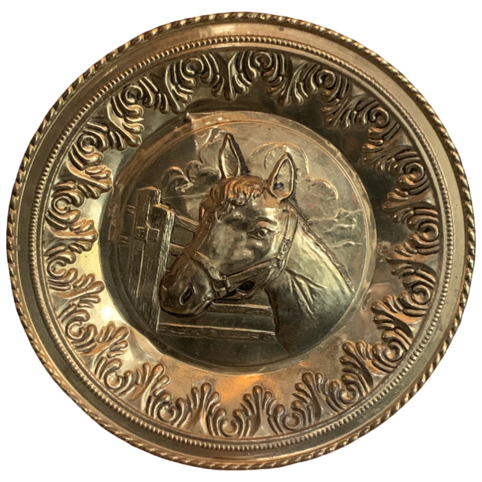 Decorative brass plate with a horse's head in the center on a white background