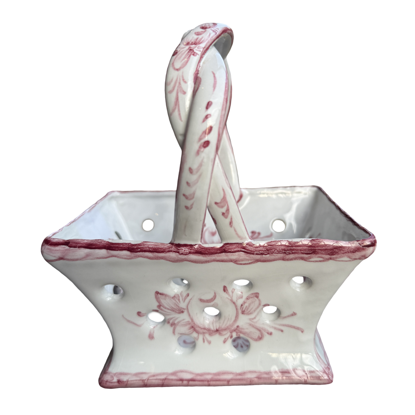White ceramic basket with pink floral patterns and matching spoon on a white background