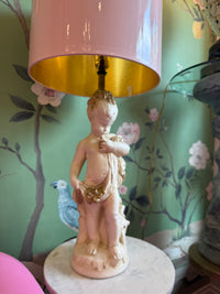 Decorative lamp with a figurine on a floral-patterned surface