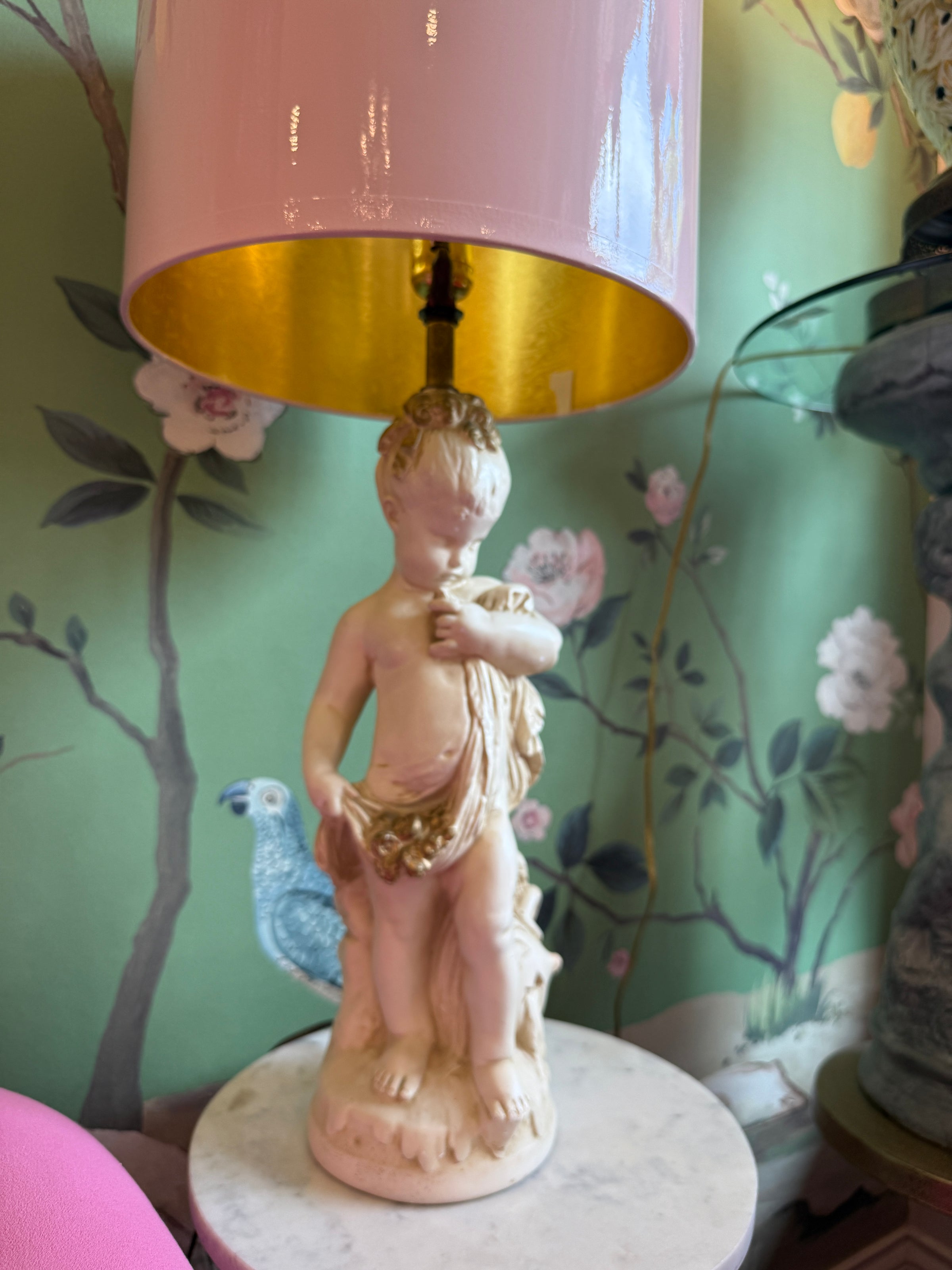 Decorative lamp with a figurine on a floral-patterned surface