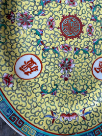Decorative plate with intricate floral and swirling patterns on a yellow background
