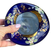 Decorative blue dish with floral patterns held by a hand