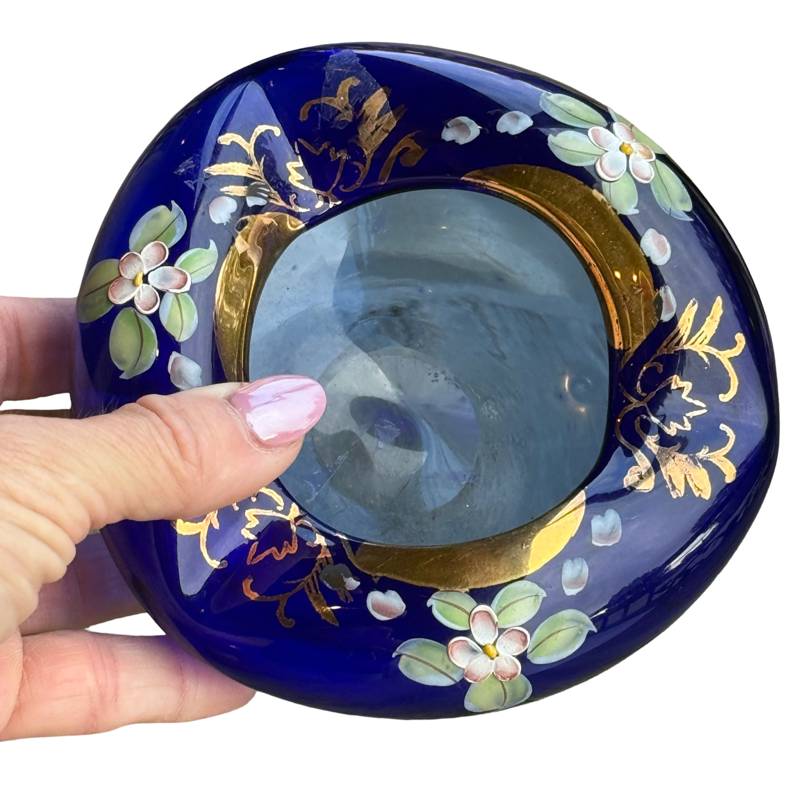 Decorative blue dish with floral patterns held by a hand