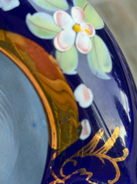 Decorative ceramic plate with floral design on a blue background