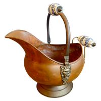 Bronze pitcher with decorative handles on a white background