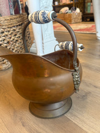 Decorative wall sconce with a brown glass shade on a wooden wall.