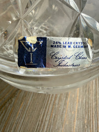 Close-up of a crystal glass with a brand label on a wooden surface