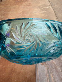 Blue glass vase with intricate cut patterns on a wooden surface