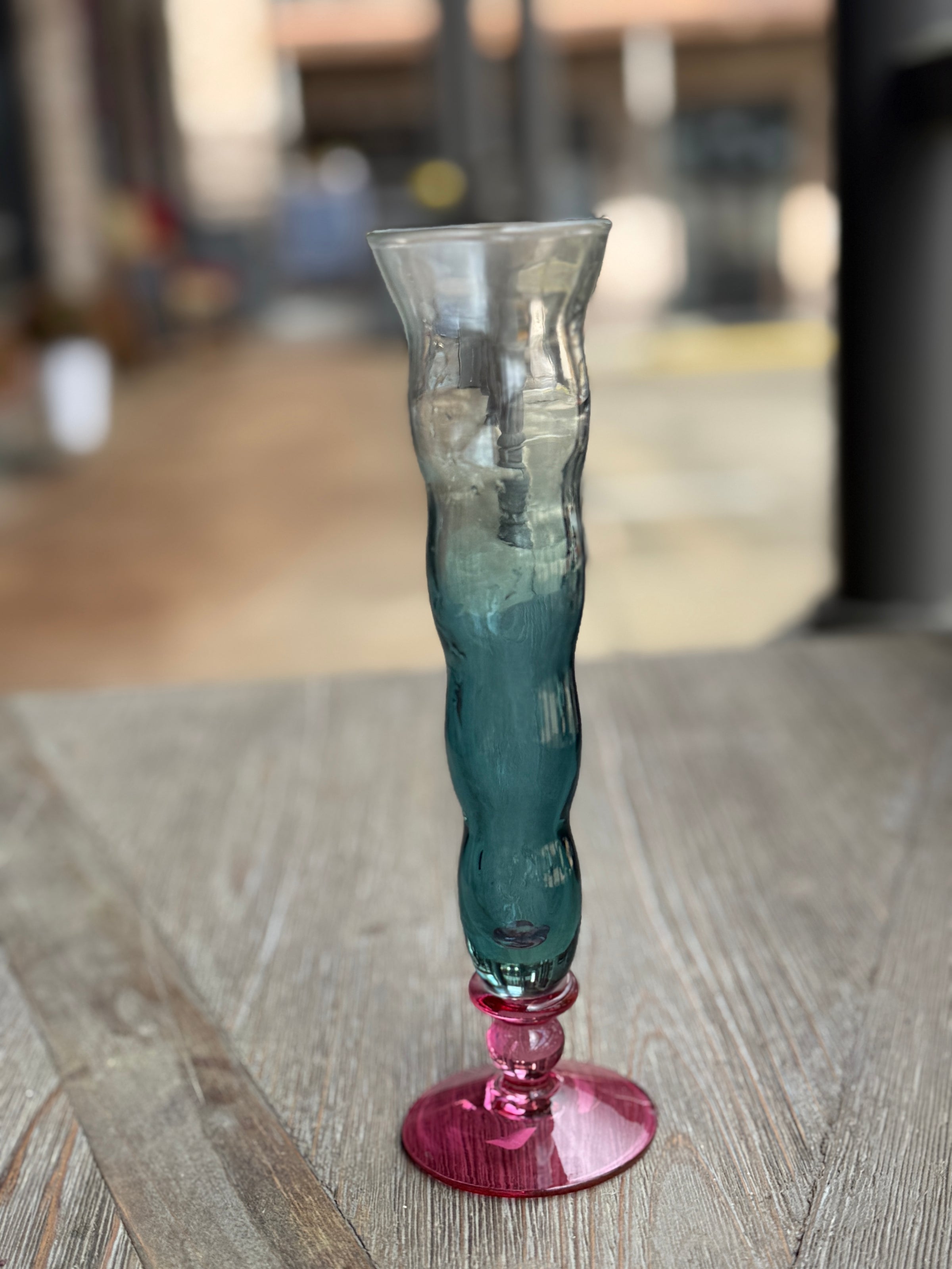 Glass vase with wavy design on a wooden surface