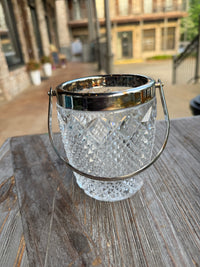 Decorative glass bowl with metal rim on a wooden surface