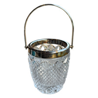 Clear glass ice bucket with silver rim and handle on a white background