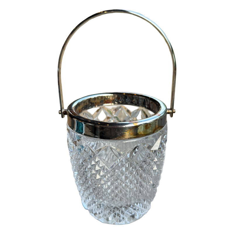 Clear glass ice bucket with silver rim and handle on a white background