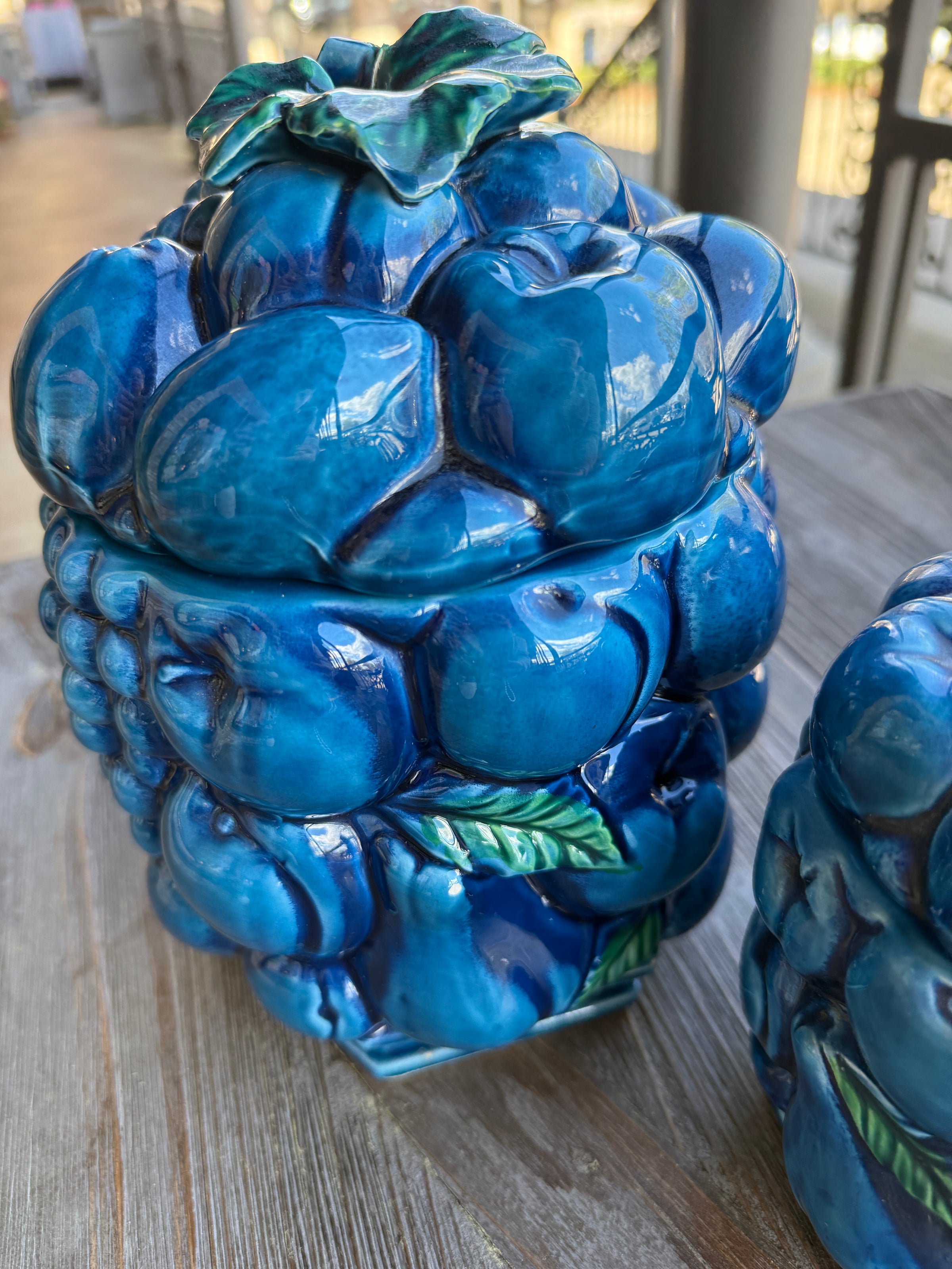 Blue ceramic fruit sculpture on a wooden surface