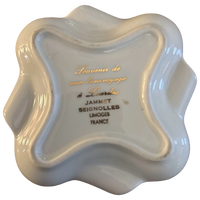 White ceramic dish with gold and black text on a white background
