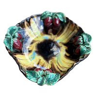 Decorative ceramic bowl with sunflower and berry design on a white background