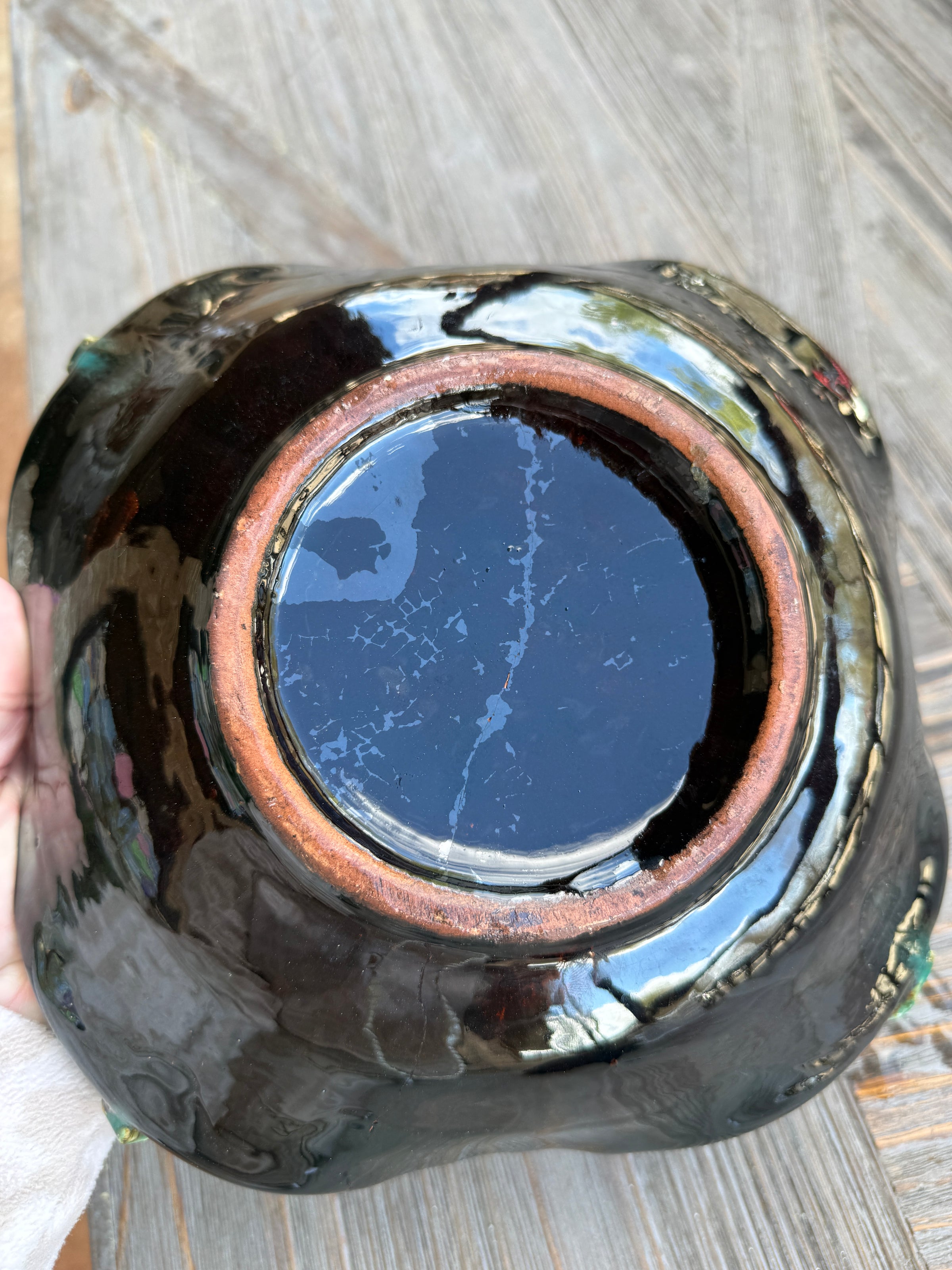 Black ceramic bowl with a glossy finish on a wooden surface
