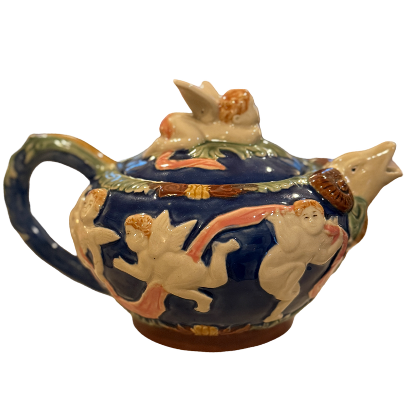 Decorative ceramic teapot with figurines on a white background