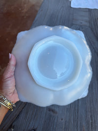 White ceramic bowl held by a hand on a wooden surface