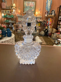 Clear glass candle holder on a brown surface with a decorative background