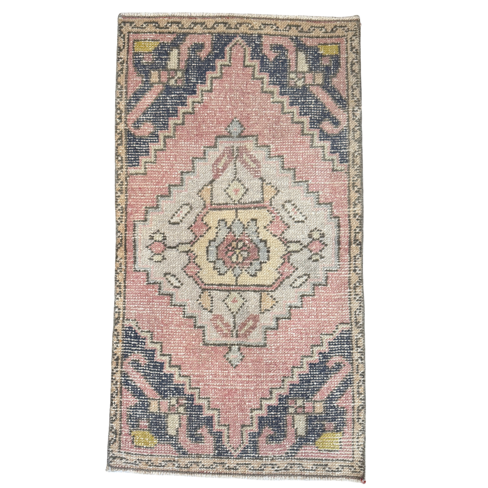 Decorative rug with a pink and blue geometric pattern on a white background