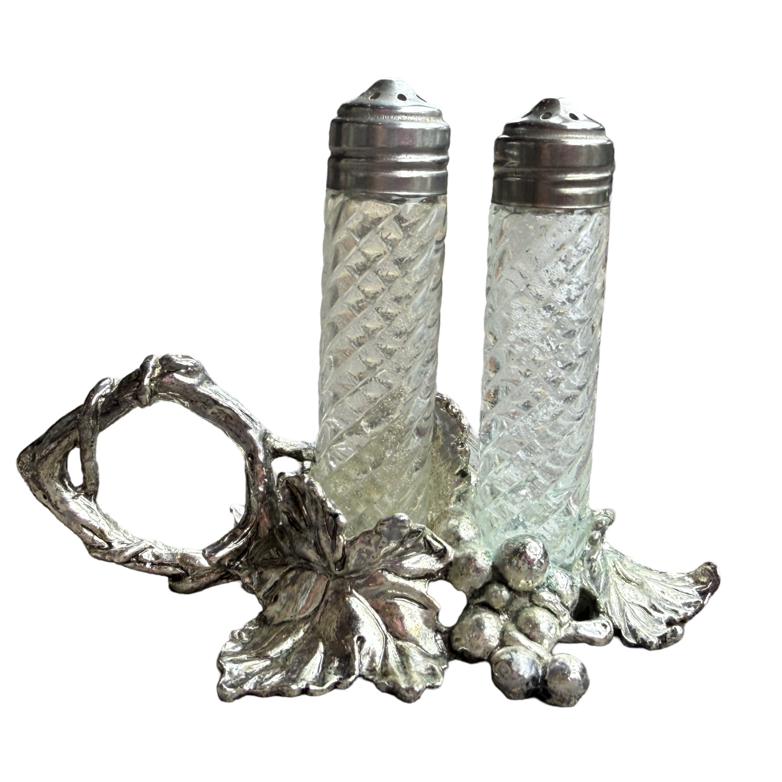 Decorative salt and pepper shakers with a silver holder on a white background