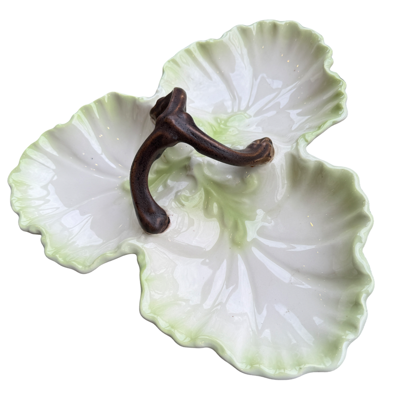 Decorative ceramic leaf-shaped dish with a brown hook on a white background