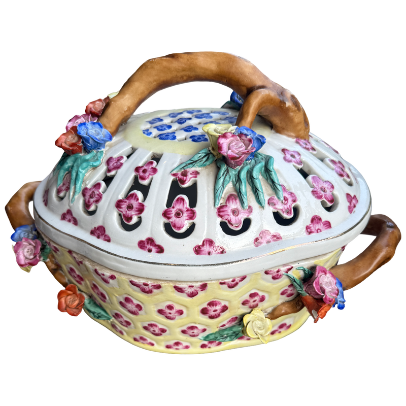 Decorative ceramic pot with floral designs and wooden handles on a white background