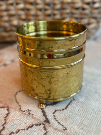 Gold textured container on a textured surface with woven background