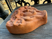 Brown soap bar with a unique texture on a wooden surface