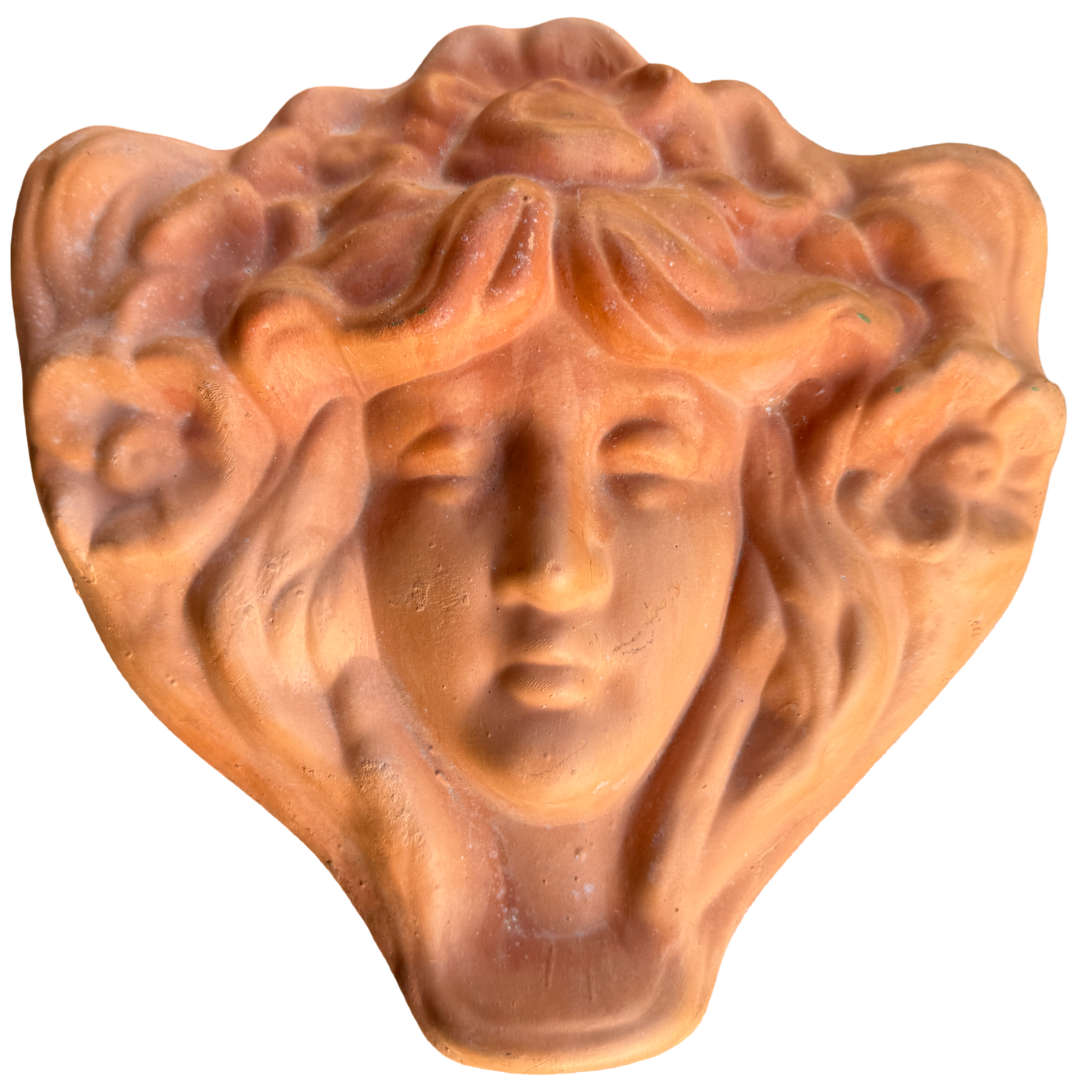 Terracotta sculpture of a face with flowing hair on a white background
