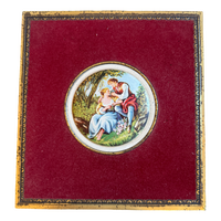Decorative box with a circular painting of a couple on a red background