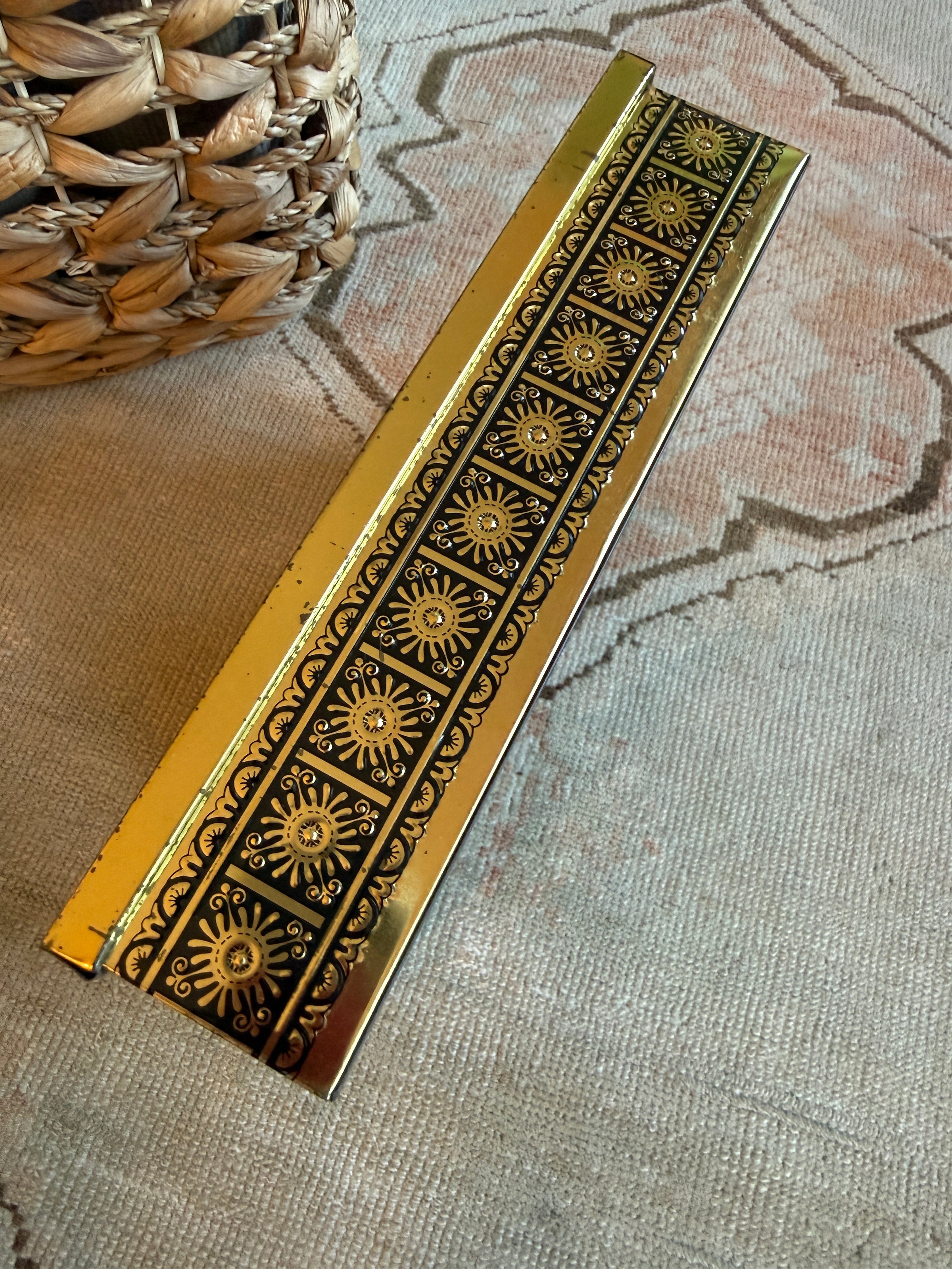 Decorative gold strip with intricate patterns on a textured surface