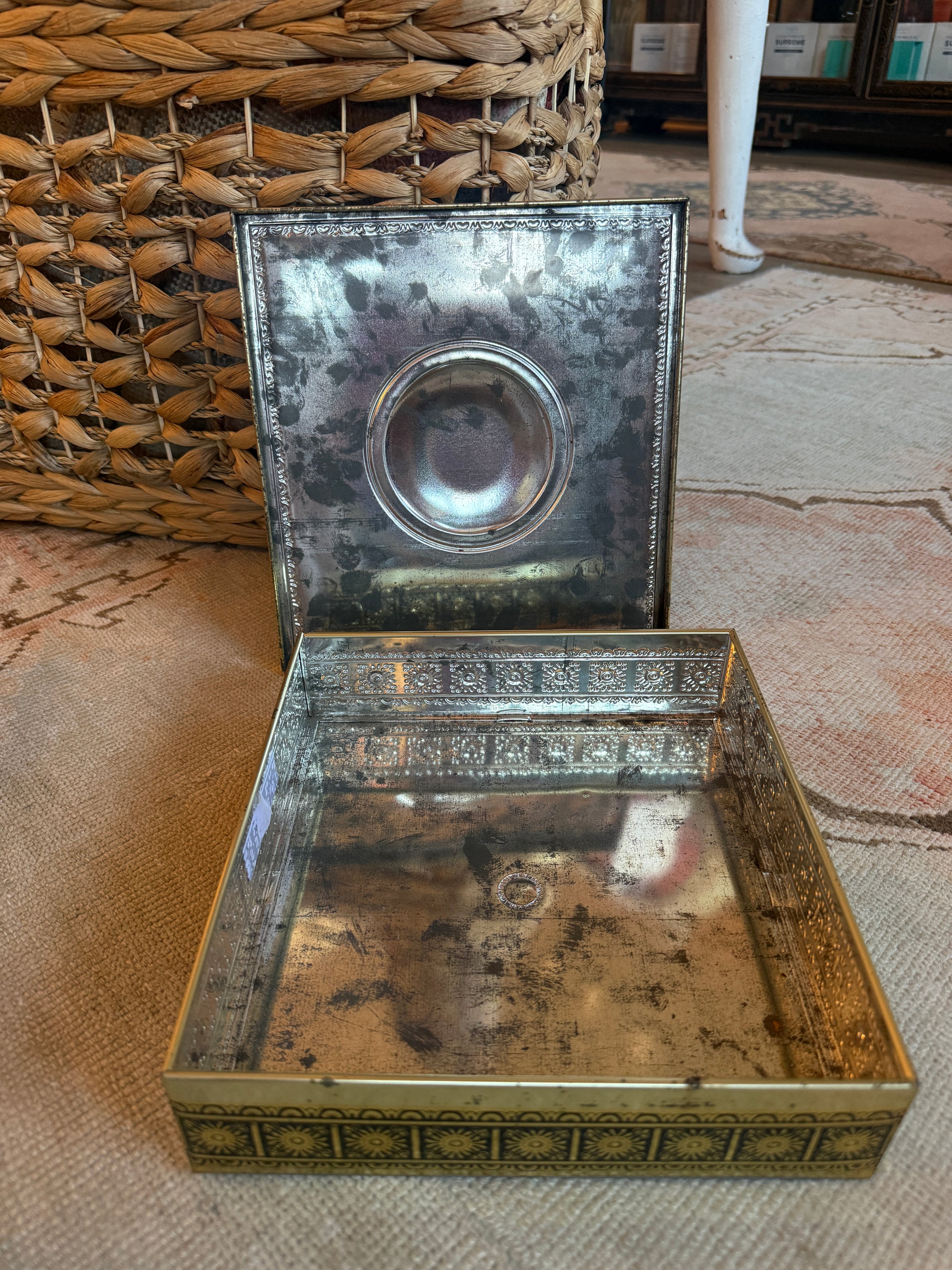 Decorative metal box with intricate designs on a textured surface